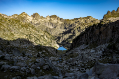 Lago en el fondo de un valle con montañas y sombras